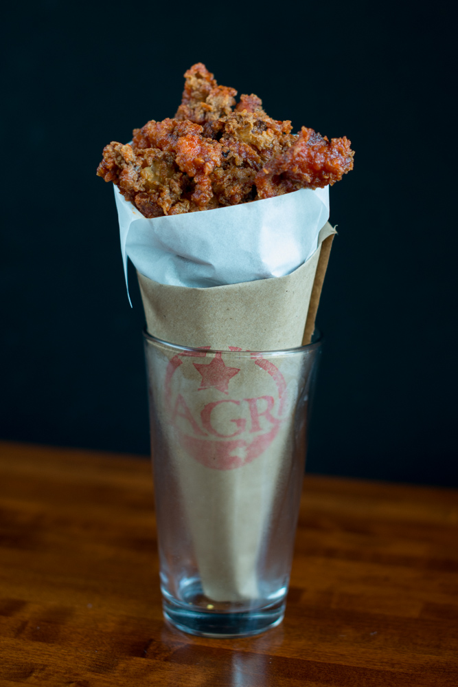 The sriracha-honey fried chicken skins at American Grocery are irresistibly crunchy, fatty, spicy, sweet, and tangy. (Photo credit: Aaron Greene)