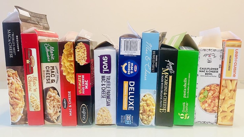 Collection of opened frozen mac and cheese boxes standing upright in a row
