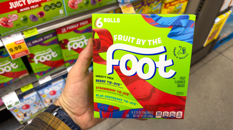 Hand holding a box of Fruit By The Foot in the grocery aisle