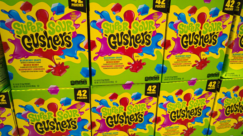 Boxes of Gushers Super Sour fruit snack stacked at a grocery store