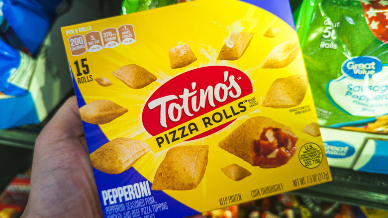 Hand holding a box of Totino's frozen pizza rolls