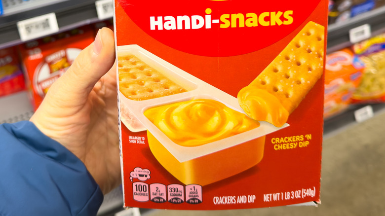Package of Handi-Snacks held by a customer in a supermarket