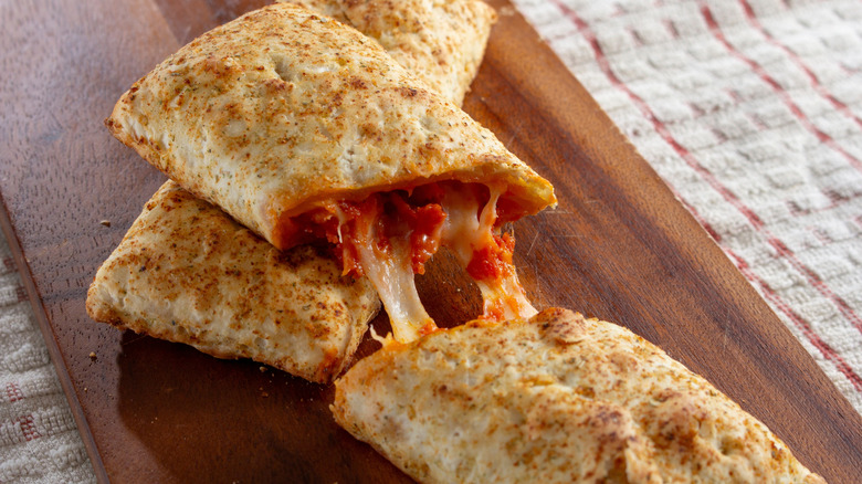 Pair of Hot Pockets with one sliced open to reveal pizza filling