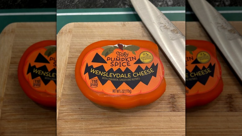 A wedge of Scary Pumpkin Spice Wensleydale Cheese on a cutting board with knife