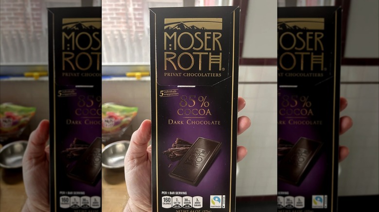 Person holding Moser Roth 85% Cocoa Dark Chocolate Bar