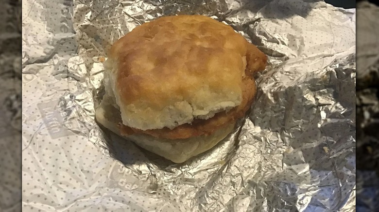 A chicken biscuit sandwich sitting on wrapper