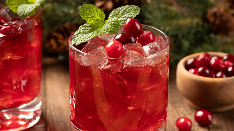 Glasses of cranberry juice over ice with fresh cranberry and mint sprig garnishes
