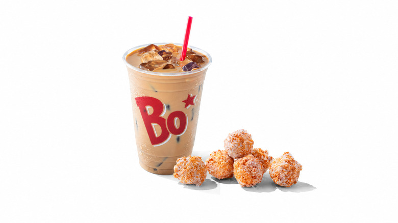 Donut bites sit in a styrofoam takeout container.