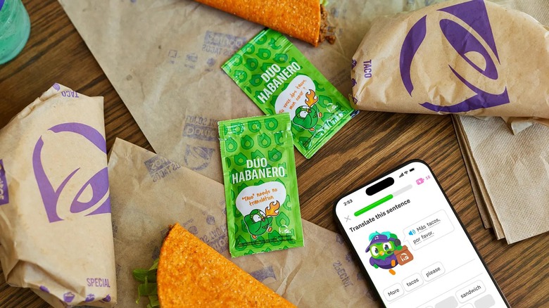 Sauce packets sit on a table with tacos from Taco Bell.