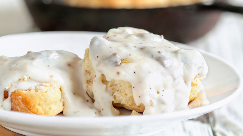 Sausage gravy on biscuits on white plate