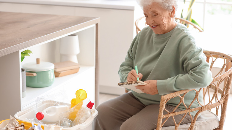 Senior woman with garbage bins