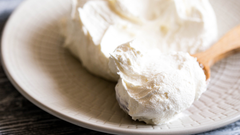 Fresh mascarpone on a wooden spoon