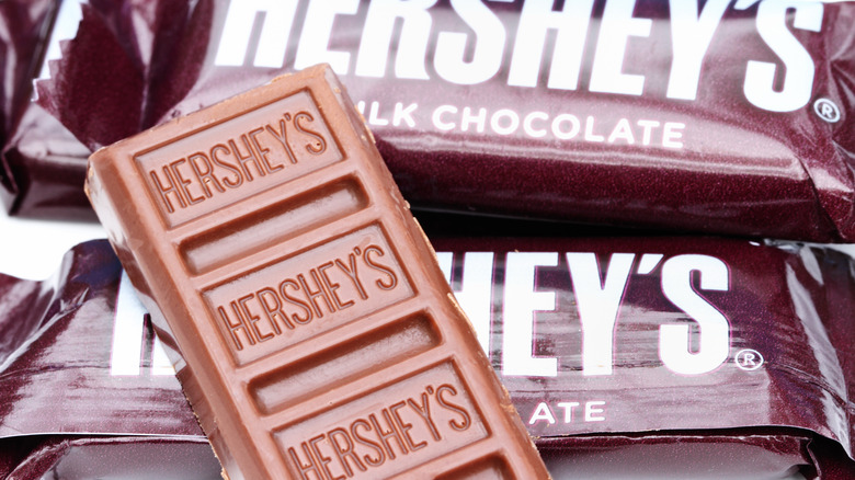 Close-up image of unwrapped Hershey's chocolate on top of Hershey's wrappers