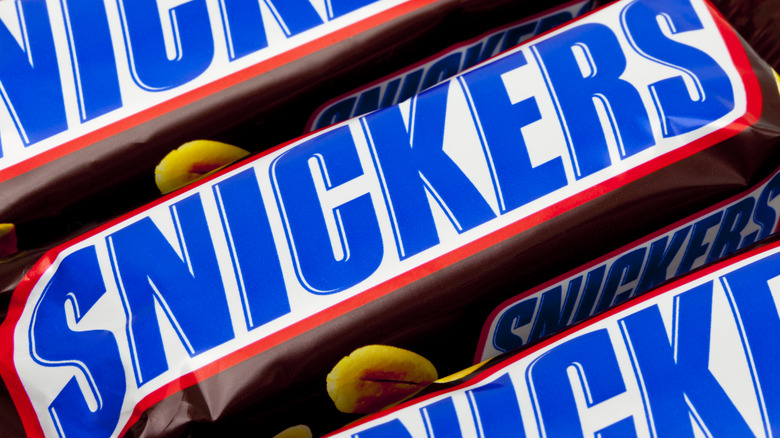 Close-up image of the wrappers of three snickers bars
