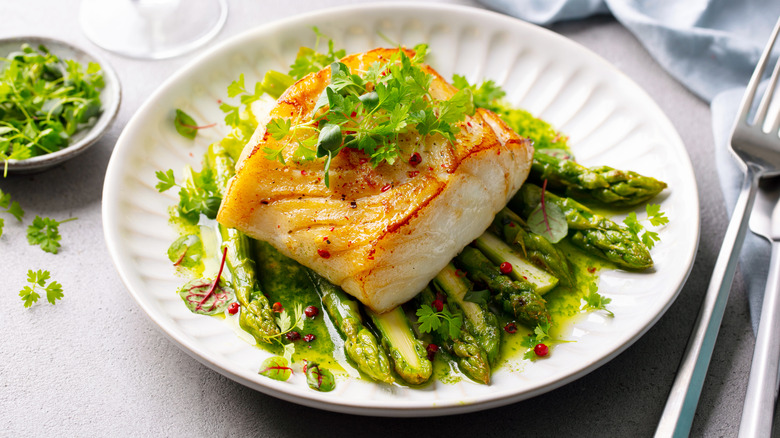 Fried cod with asparagus on a plate