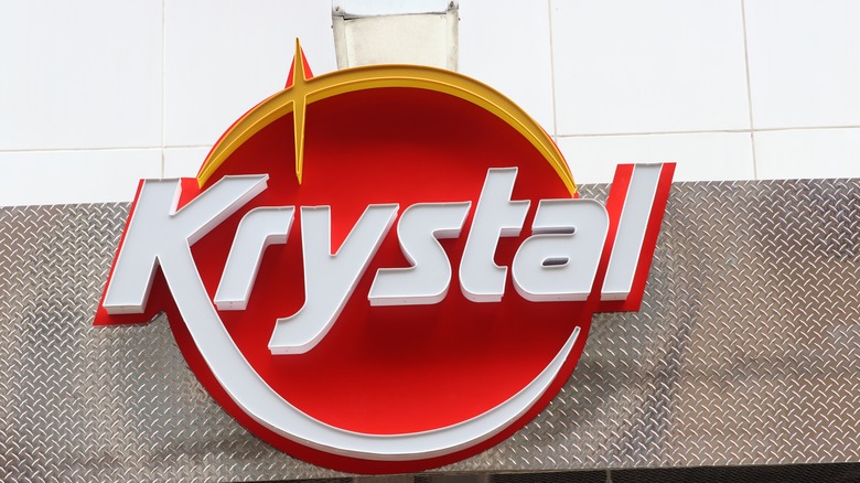 Close-up of a Krystal sign in front of diamond plate