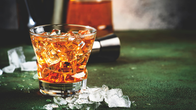 glass filled with ice and a brown beverage