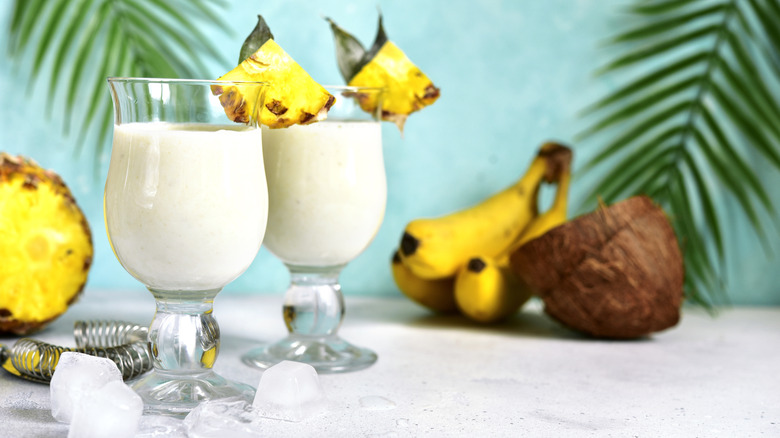 white drink in a glass garnished with pineapple