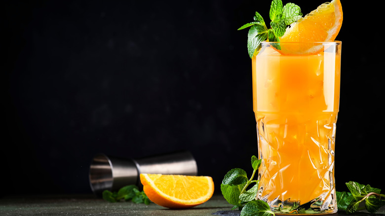 orange drink in a glass garnished with an orange wedge