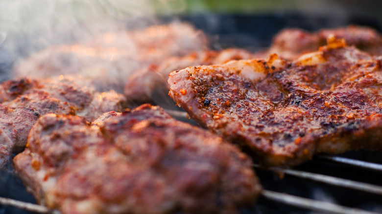 Chuck steaks are sizzling on a grill