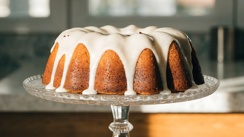 A Harvey Wallbanger cake sits on a glass pedestal cake plate