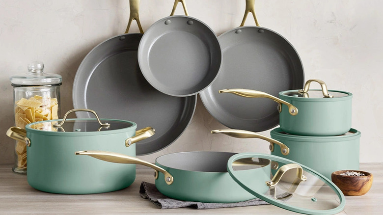 The pieces of a GreenPan Jewel Pro 11-piece Cookware Set are arranged hanging above and sitting on a counter