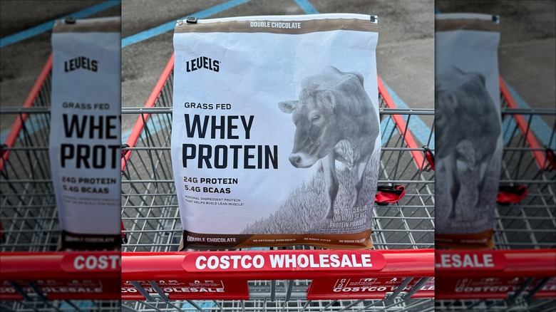 A bag of Levels Double Chocolate Grass Fed Whey Protein sits in a Costco shopping cart.