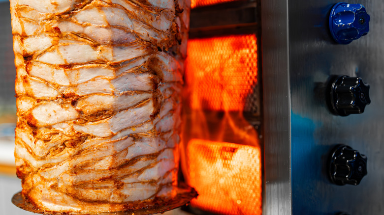 Chicken roasting on a gyro spit.