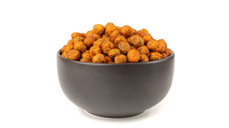 Roasted and spiced chickpeas in a black bowl with a white background