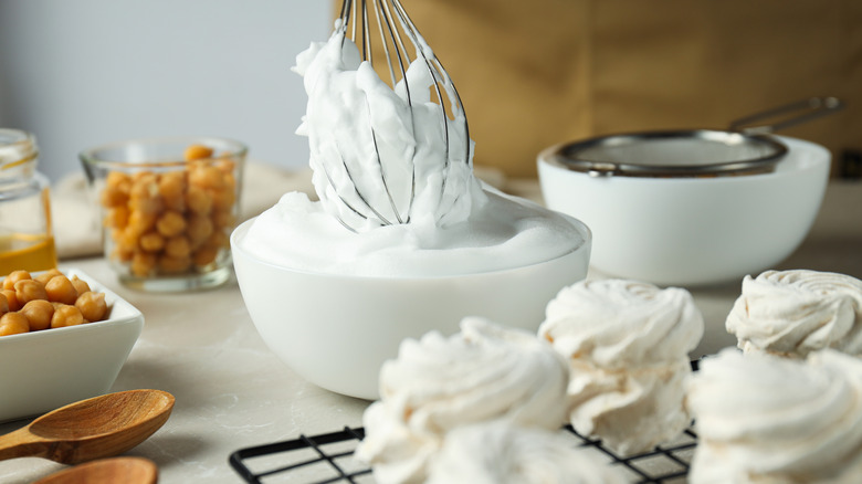A whisk is in a meringue mix made out of aquafaba, there are pre made meringues in the front