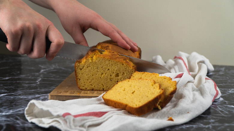 A person cutting cornbread