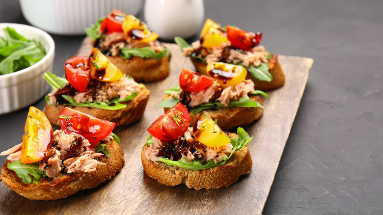 Tuna crostini with arugula, cherry tomatoes and balsamic vinegar