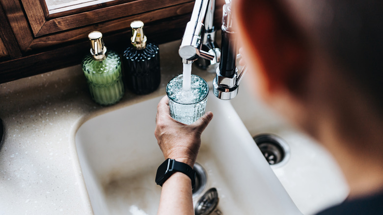 man using filtered water from sink