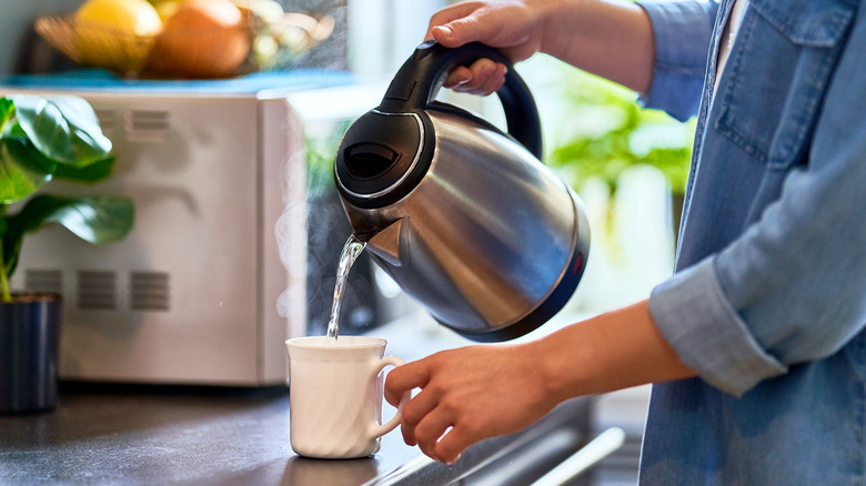woman pouring boiling water in tea 