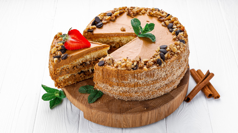 Layered coffee and walnut cake with fresh mint sprigs and cinnamon sticks