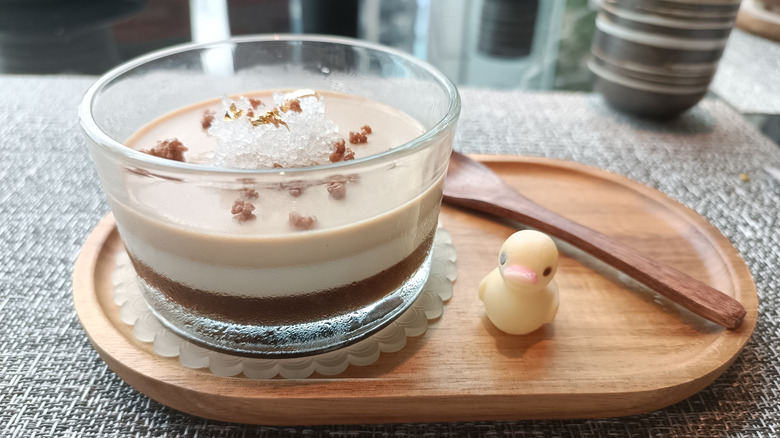 Espresso panna cotta on a wooden board with a wooden spoon