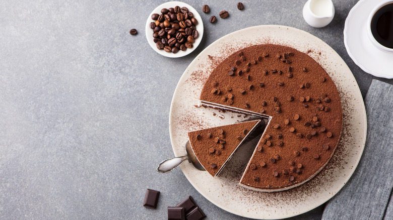 Overhead view of a round tiramisù  cake with coffee beans and chocolate chips