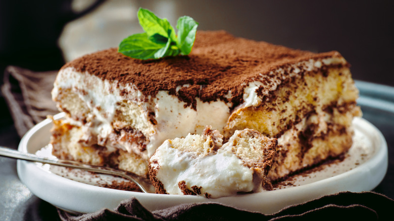 Slice of tiramisu cake on a plate with a fork