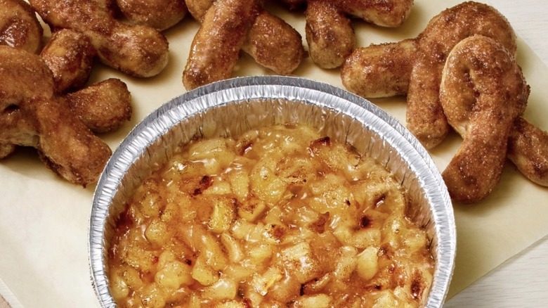 Aluminum dish of baked cinnamon apples with twists of cinnamon bread