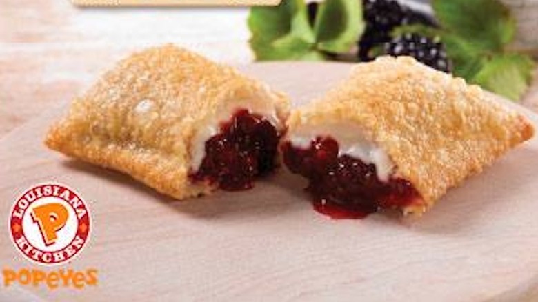 Popeyes pie split open with blackberry and cream cheese filling spilling out
