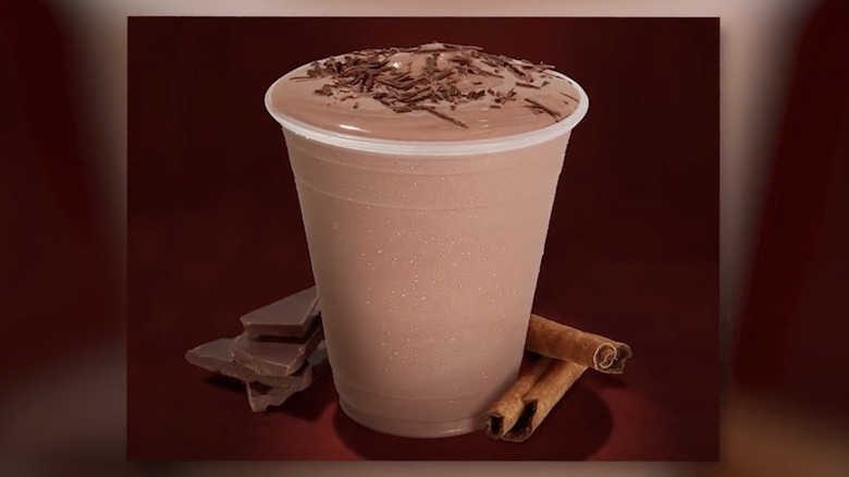 Promotional shot of milkshake with cinnamon sticks and chocolate shavings