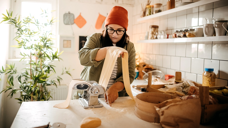 A woman makes fresh pasta in her home kitchen