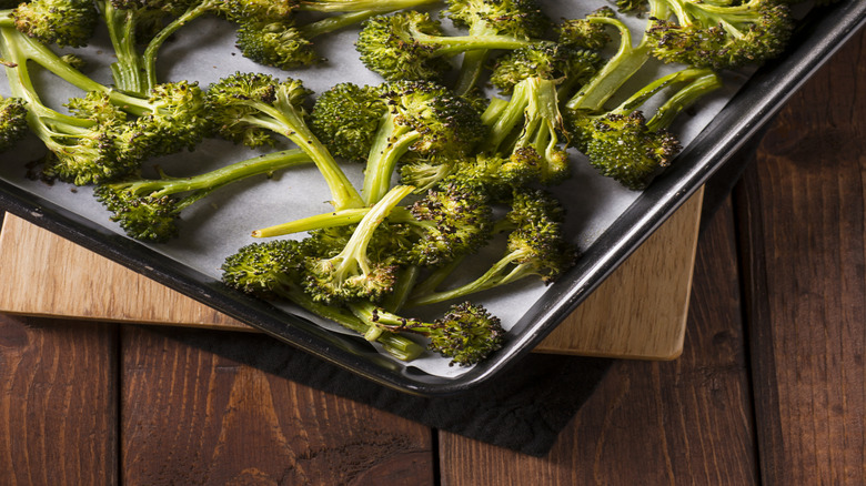 Roasted broccoli on a parchment-lined baking tray