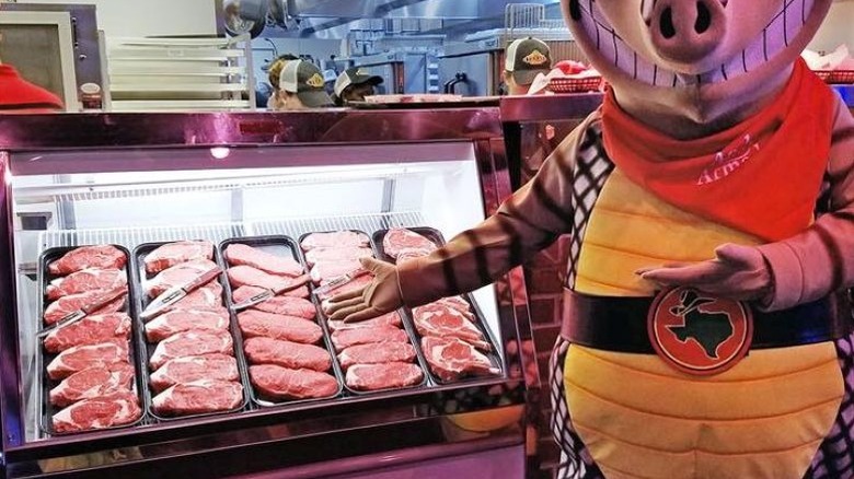 Texas Roadhouse mascot in front of in-house butcher counter