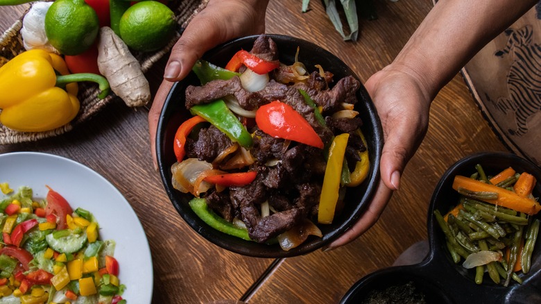 Bowl of tibs displayed with its ingredients