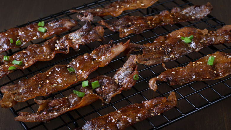 Maple glazed bacon with scallions on a cooling rack
