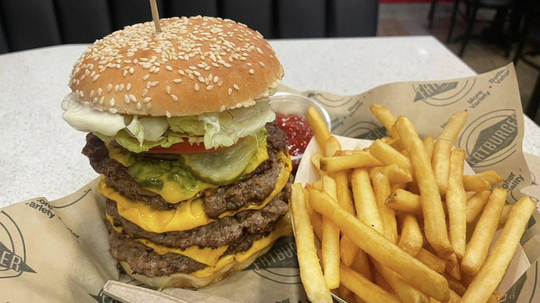 An image of the Fatburger XXXL Triple King with a side of fries.