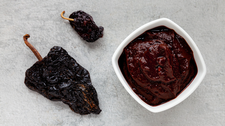 Two dried ancho chiles next to adobo sauce