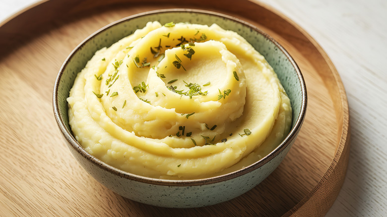 A bowl of mashed potatoes with herbs