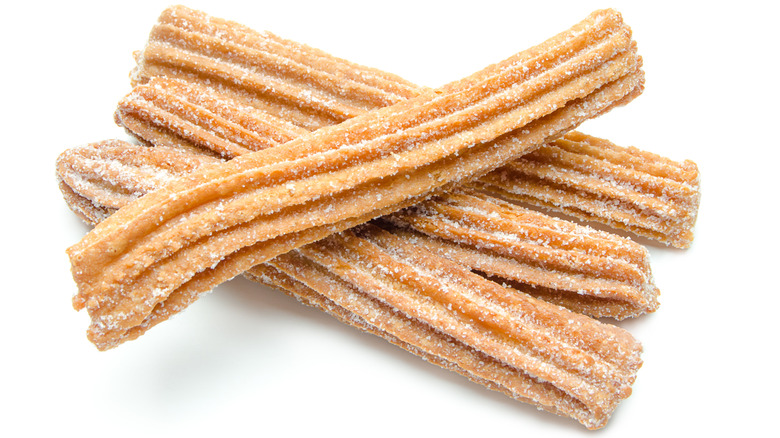 Stack of crispy churros on a white background